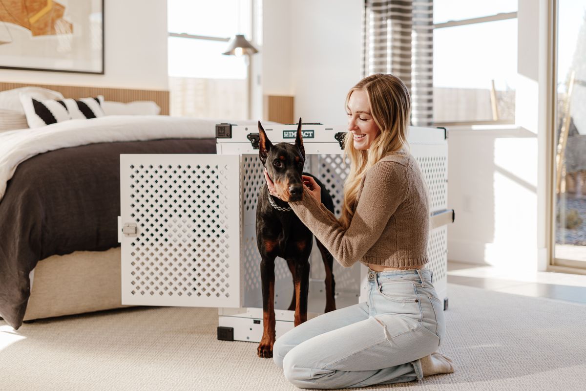 How long does crate training take - owner kneeling by dog crate